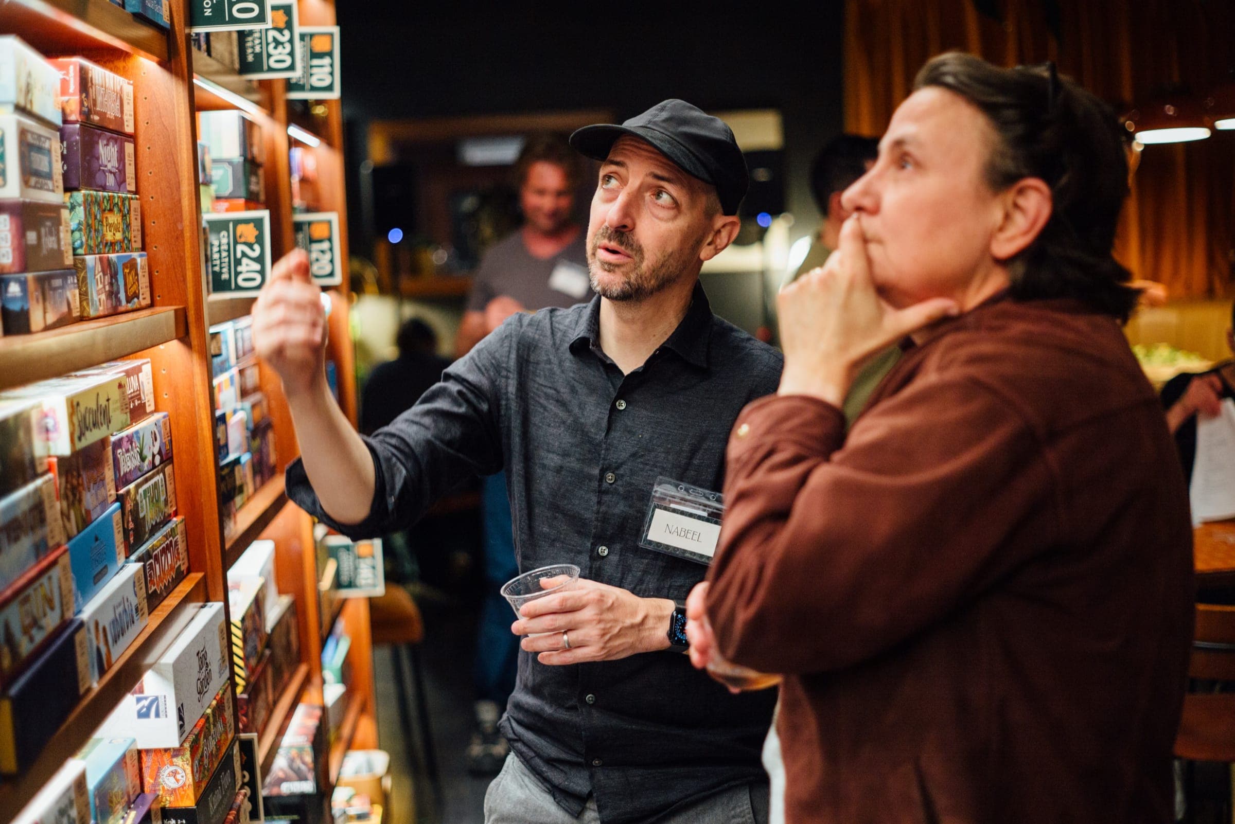Two people looking over the shelves of games