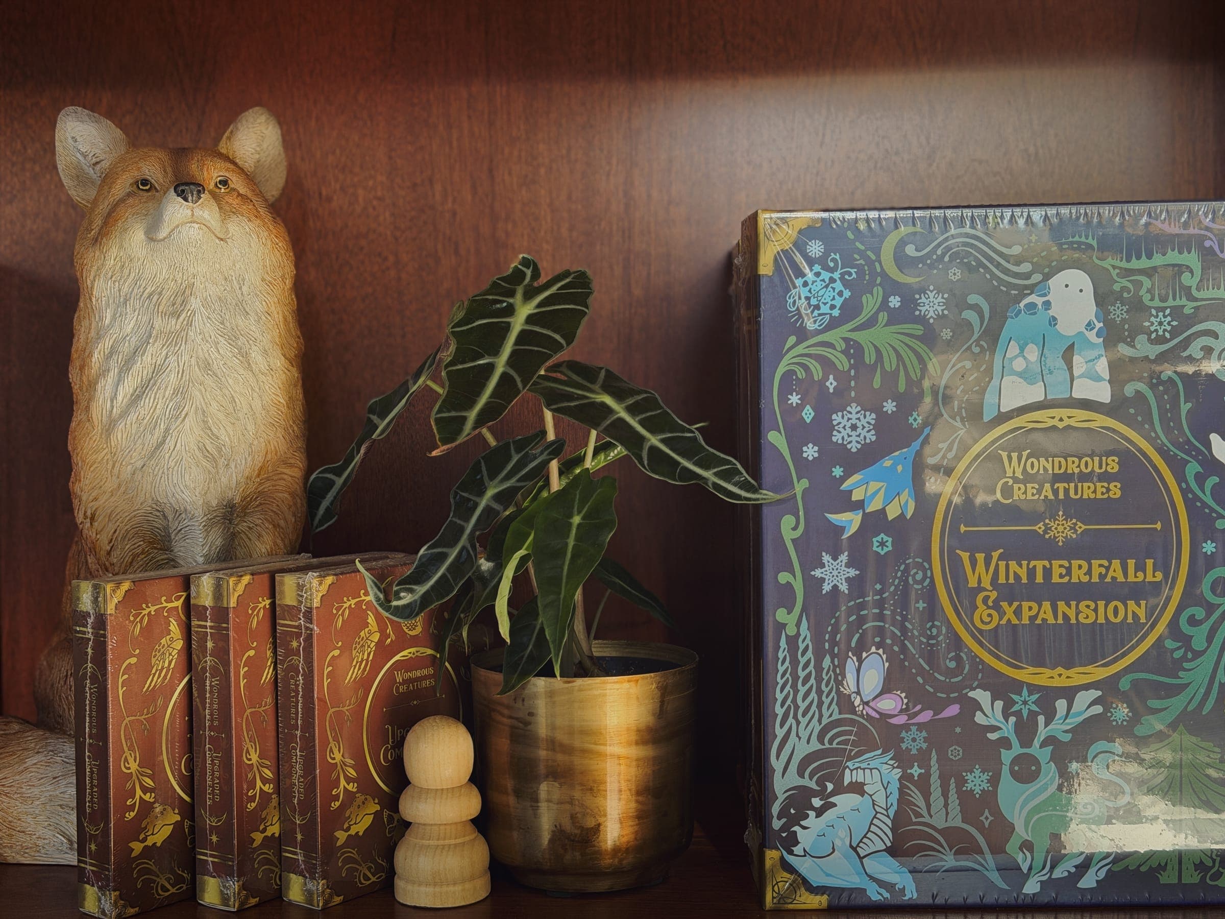 A fox figurine beside a game box on the shelf